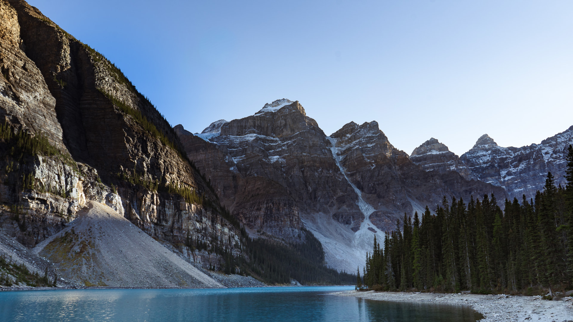 The turquoise water of Moraine Lake beneath the jagged, snow-dusted Valley of the Ten Peaks in Banff National Park.