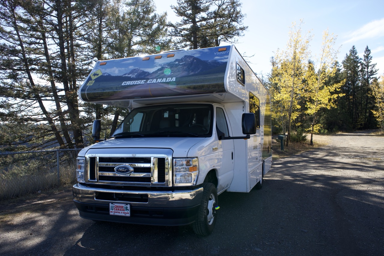Our hire campervan parked among tall evergreens on the Canadian Rockies road trip.
