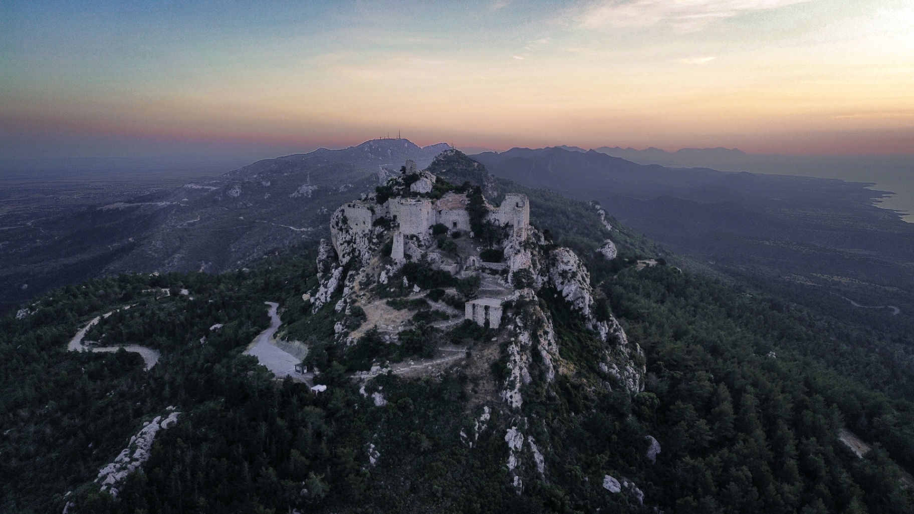 Aerial view across a stone castle and the green Kyrenia mountains of North Cyprus